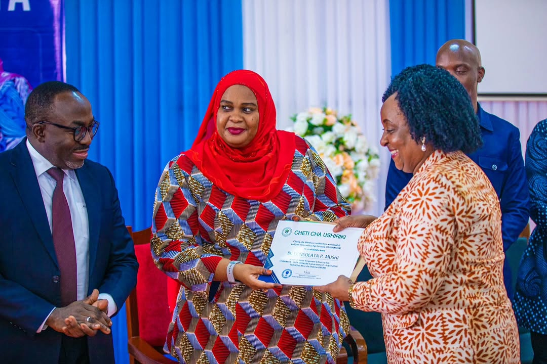 Waziri wa Habari, Sanaa, Utamaduni na Michezo Zanzibar Mhe. Riziki Pembe akikabidhi cheti cha ushiriki kwa Katibu mtendaji wa BAKITA Bi. Concolata Mushi katika Kongamano la CHAWAKITA